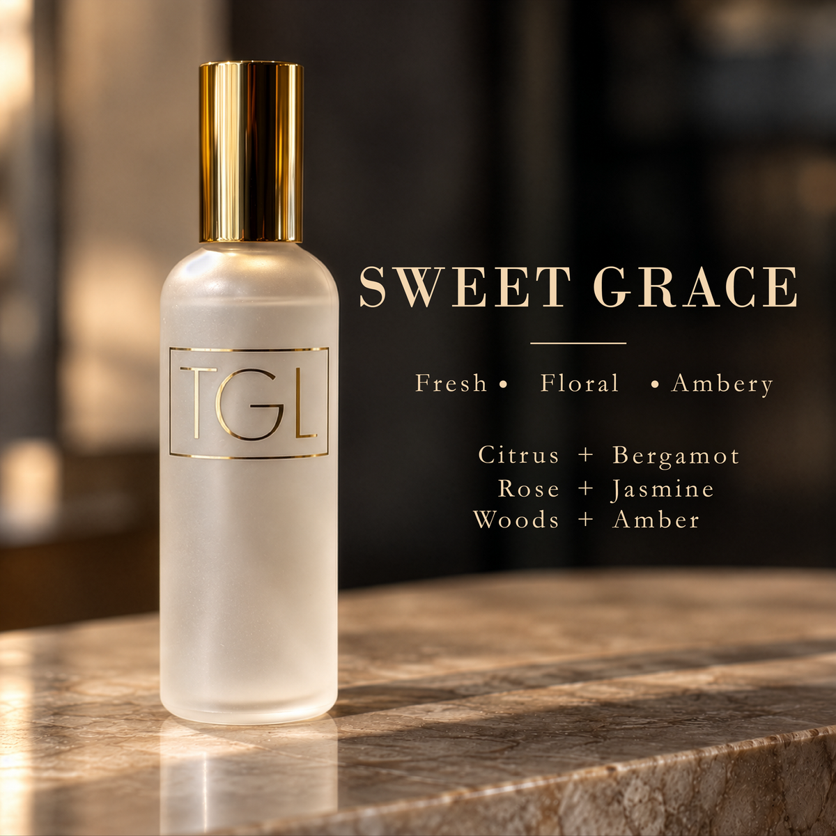A frosted glass bottle with a metallic gold cap and gold 'TGL' branding, set on a marble surface against a dark, softly blurred background. Text on the right reads 'SWEET GRACE' with scent notes: Fresh, Floral, Ambry, Citrus + Bergamot, Rose + Jasmine, Woods + Amber.