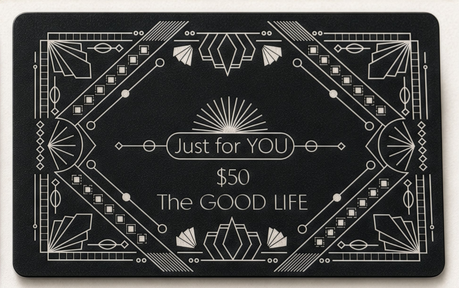 A rectangular black gift card with white Art Deco-style geometric borders and centered text reading 'Just for YOU', '$50', and 'The GOOD LIFE'.