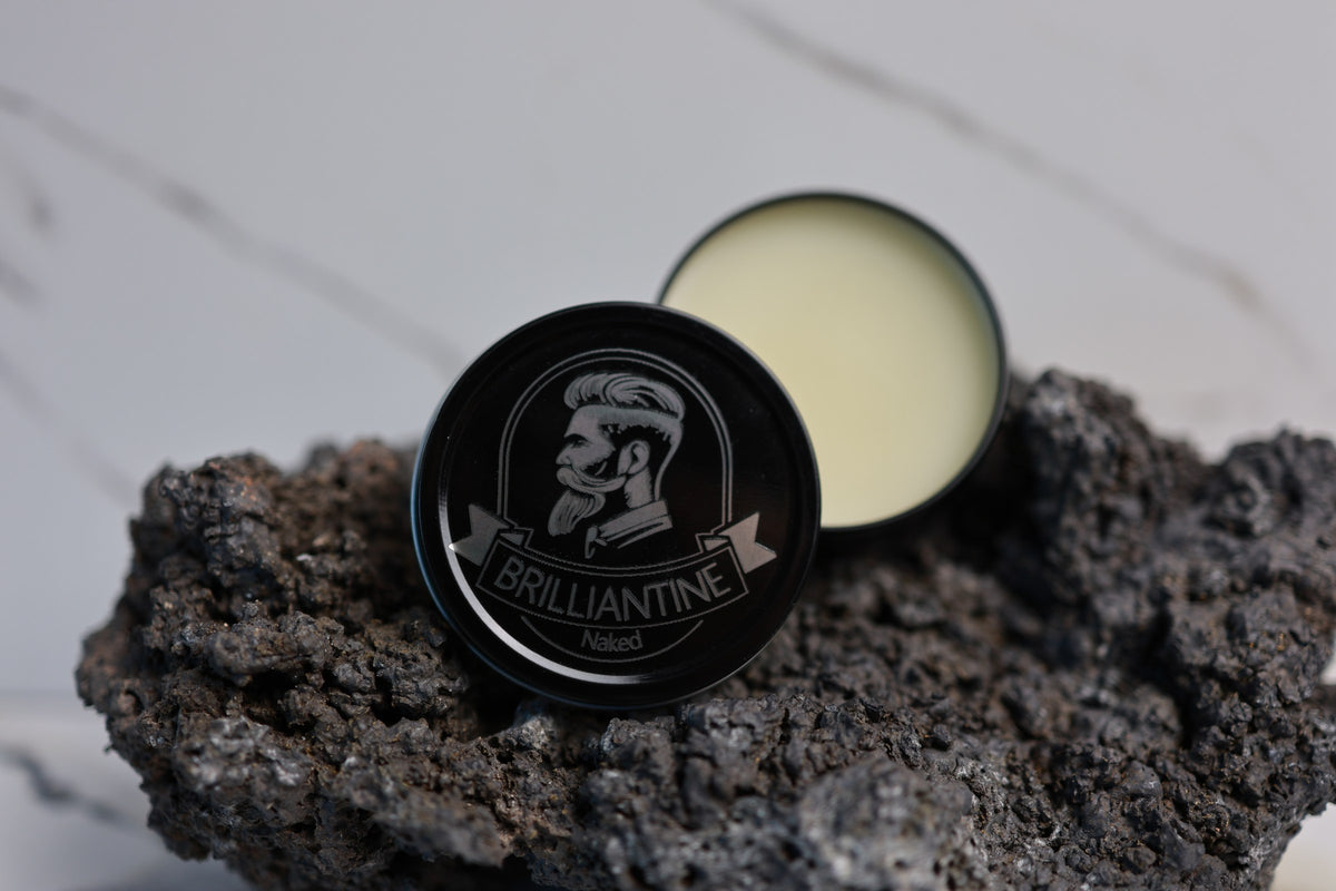 Brilliantine beard balm 2 oz open tin on lava rock