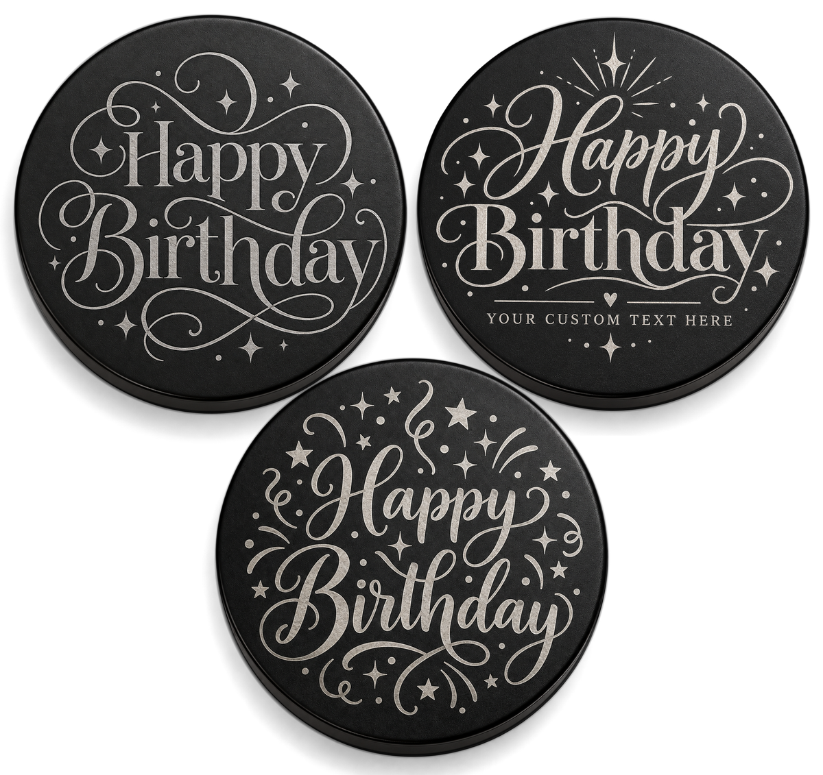 Three black candle lids engraved with birthday designs, shown together