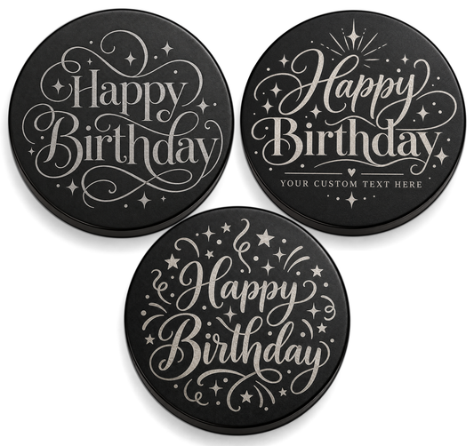 Three black candle lids engraved with birthday designs, shown together