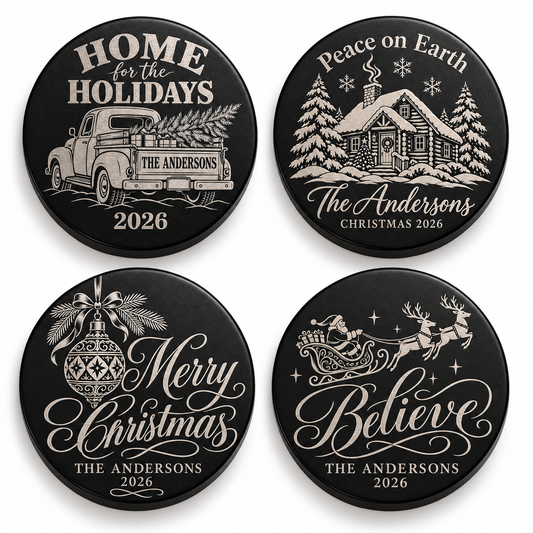 Four black candle lids engraved with christmas designs, shown together